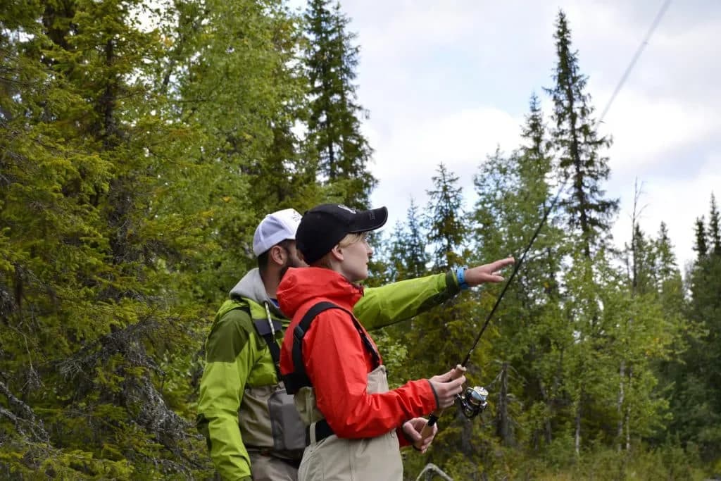 Guide qui conseille un pêcheur au bord du lac